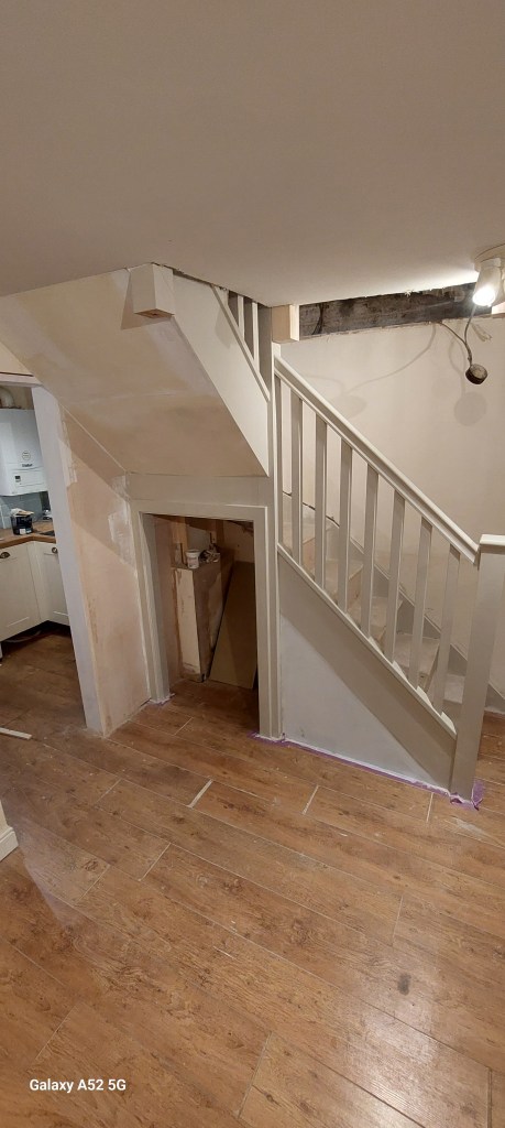 View of a staircase leading to an upper level, with wooden flooring and unfinished walls.